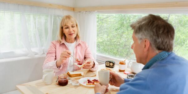 Älteres Ehepaar frühstückt im Camper Älteres Ehepaar frühstückt im Camper
